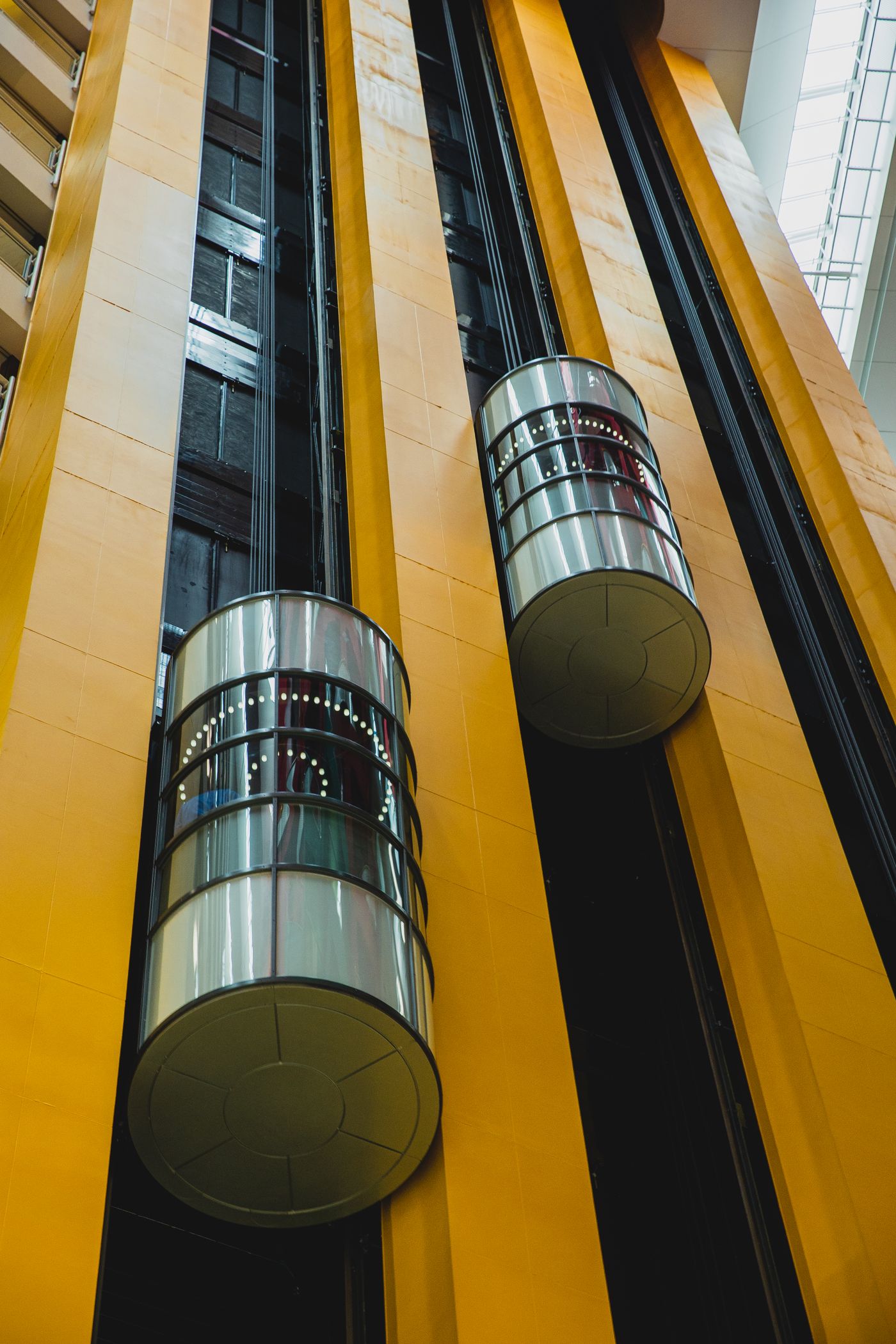 Glass elevator cars moving through a tall architectural atrium